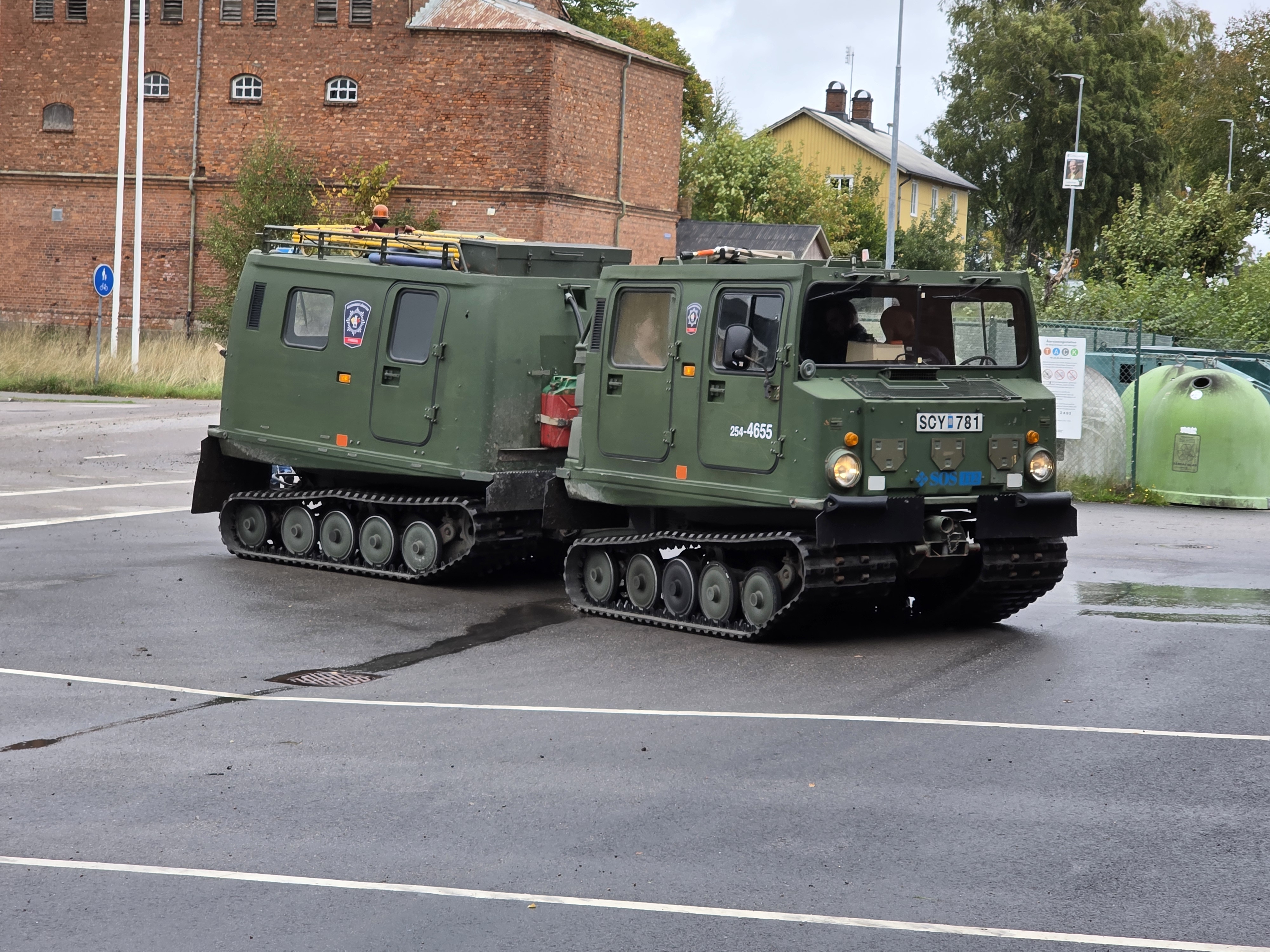 En grön bandvagn åker in på parkeringen