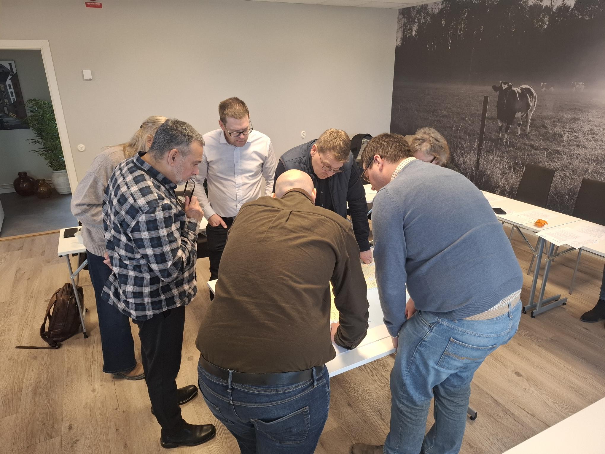 personer böjer sig fokuserat över ett bord