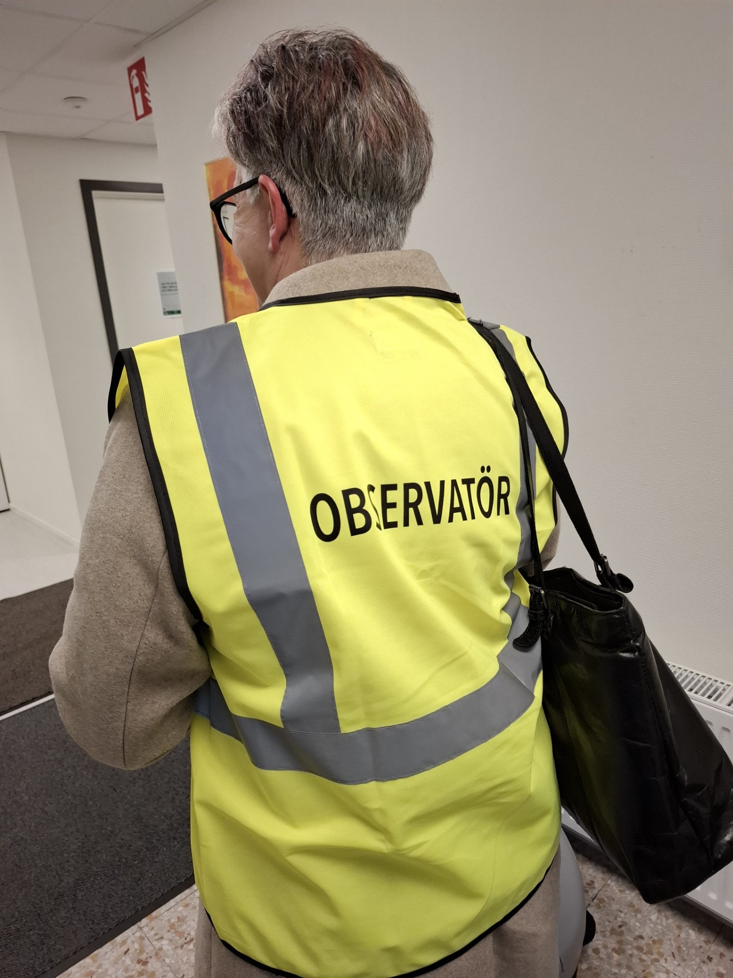 Man ser ryggen på en person med en varselväst på där det står observatör på ryggen.