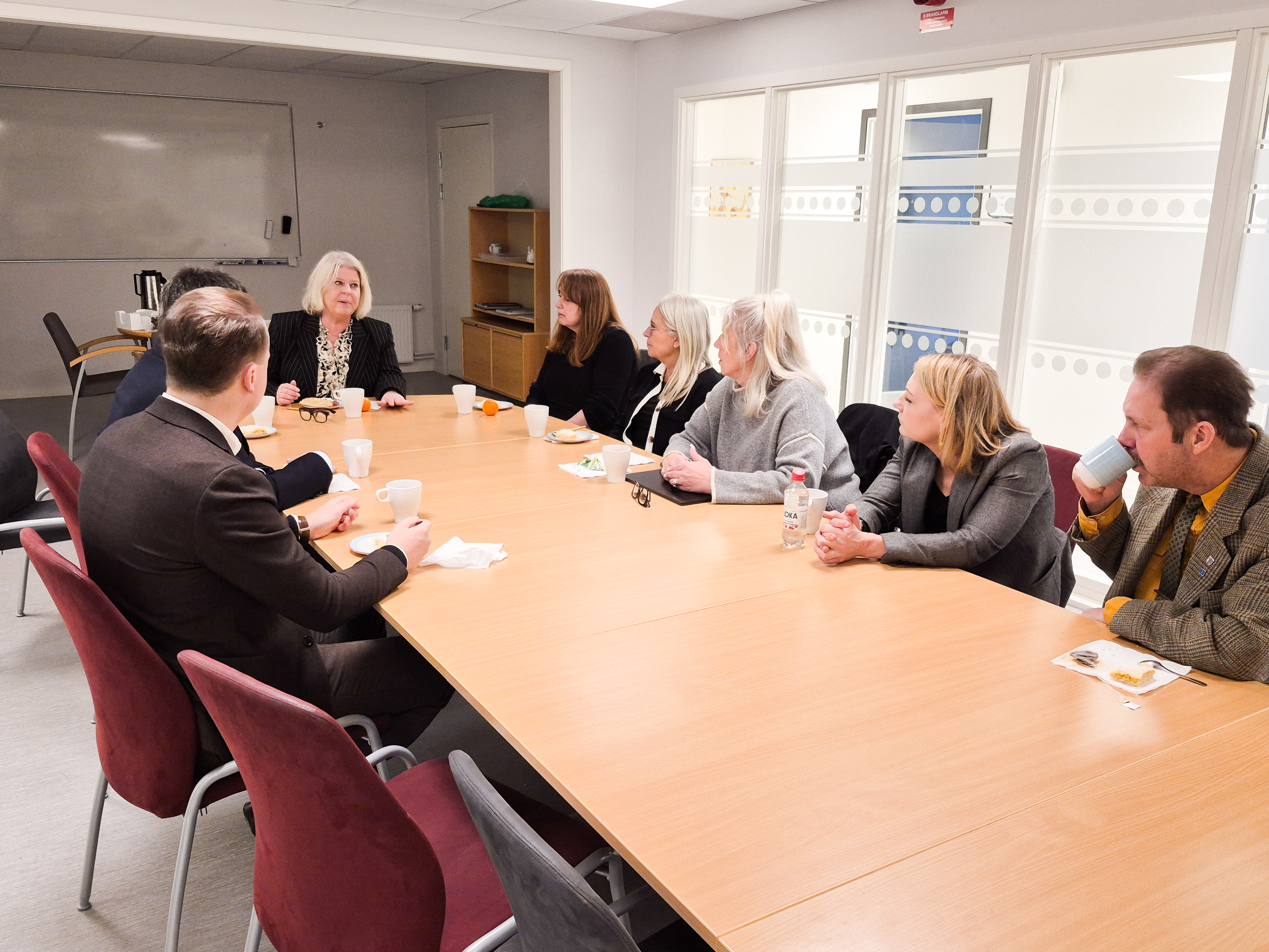 Socialtjänstministern sitter vid ett bord med chefer inom IFO och kommunchef.