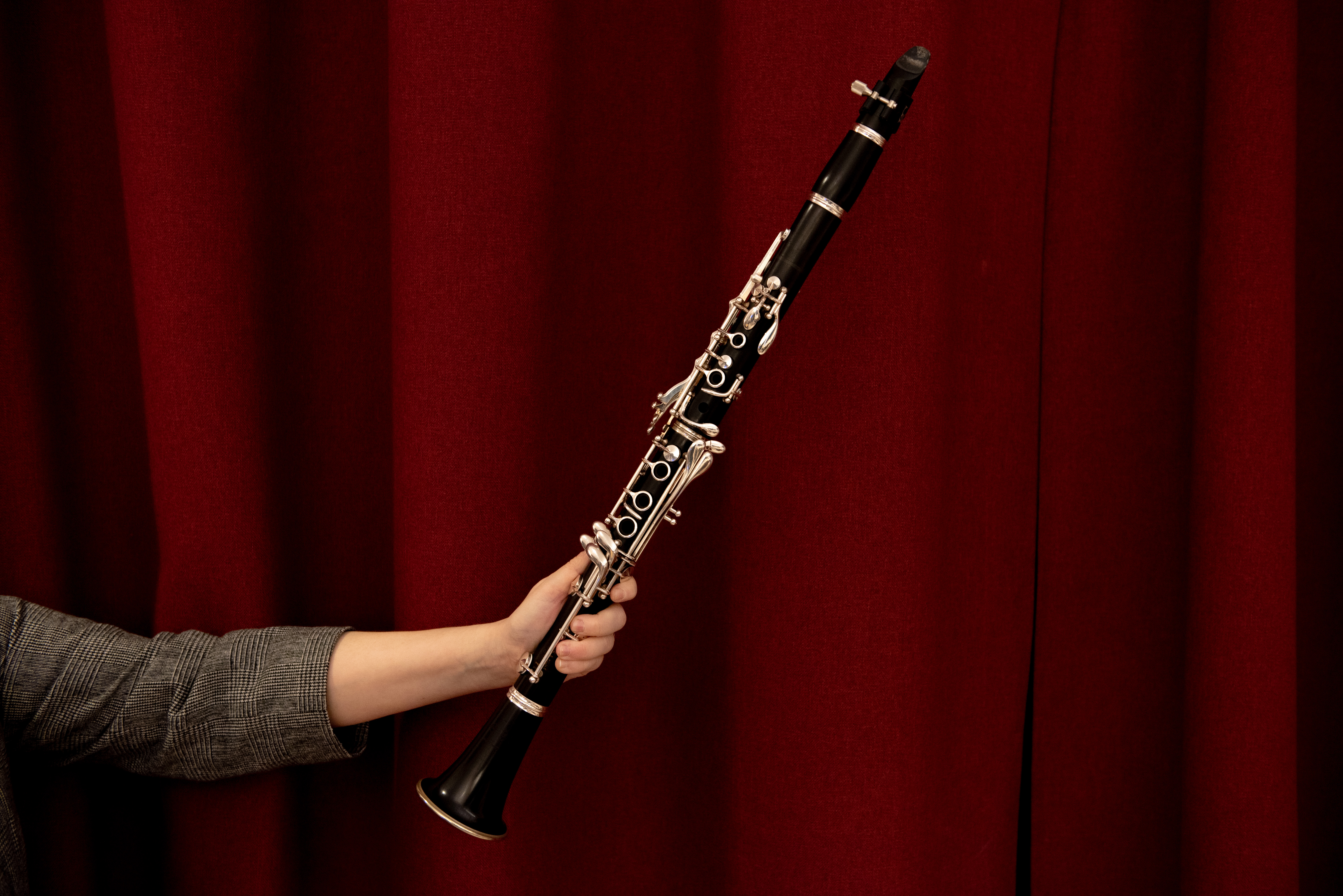 Bild på en klarinett mot ett vinrött skynke