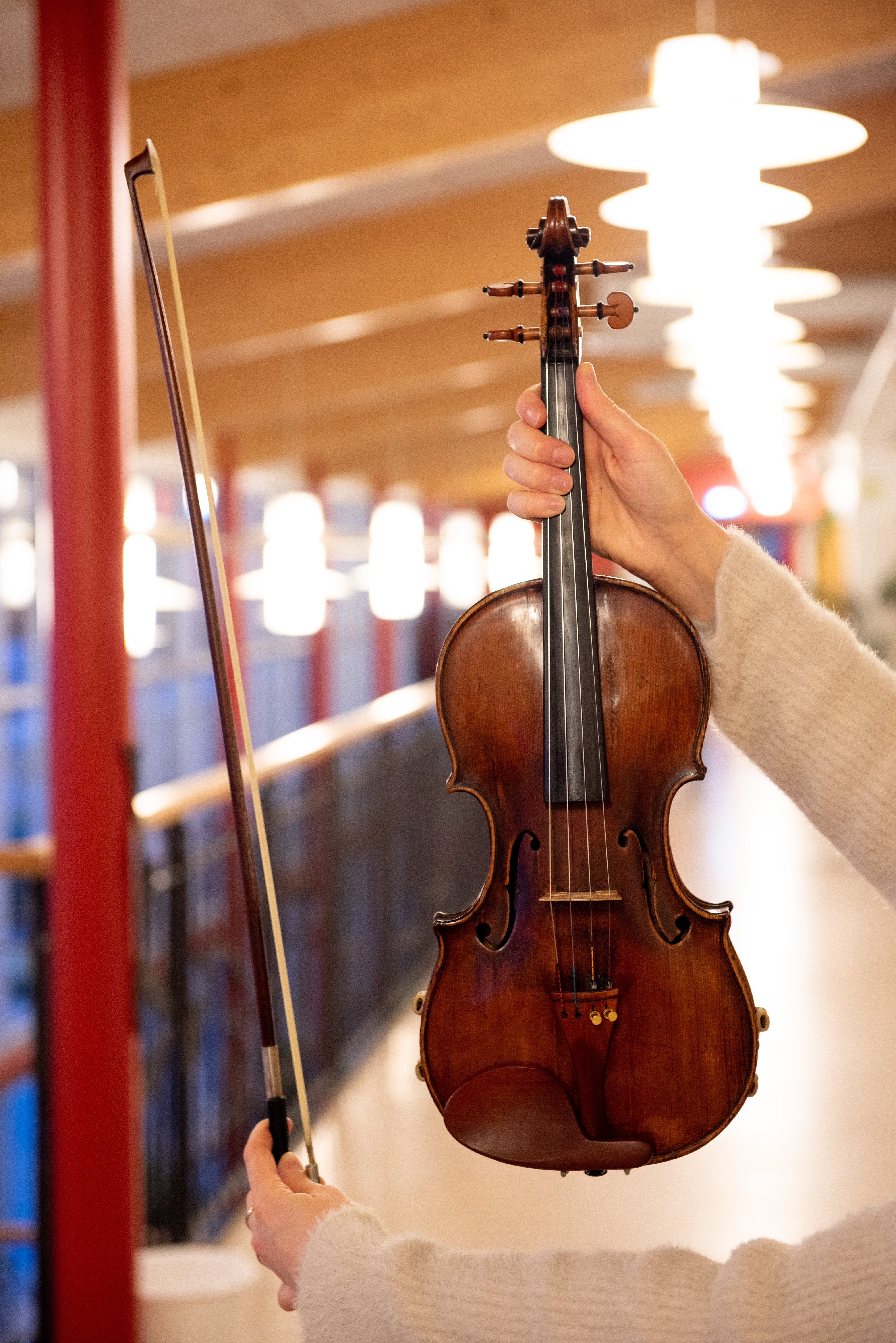 Bild på en fiol mot en lång skolkorridor