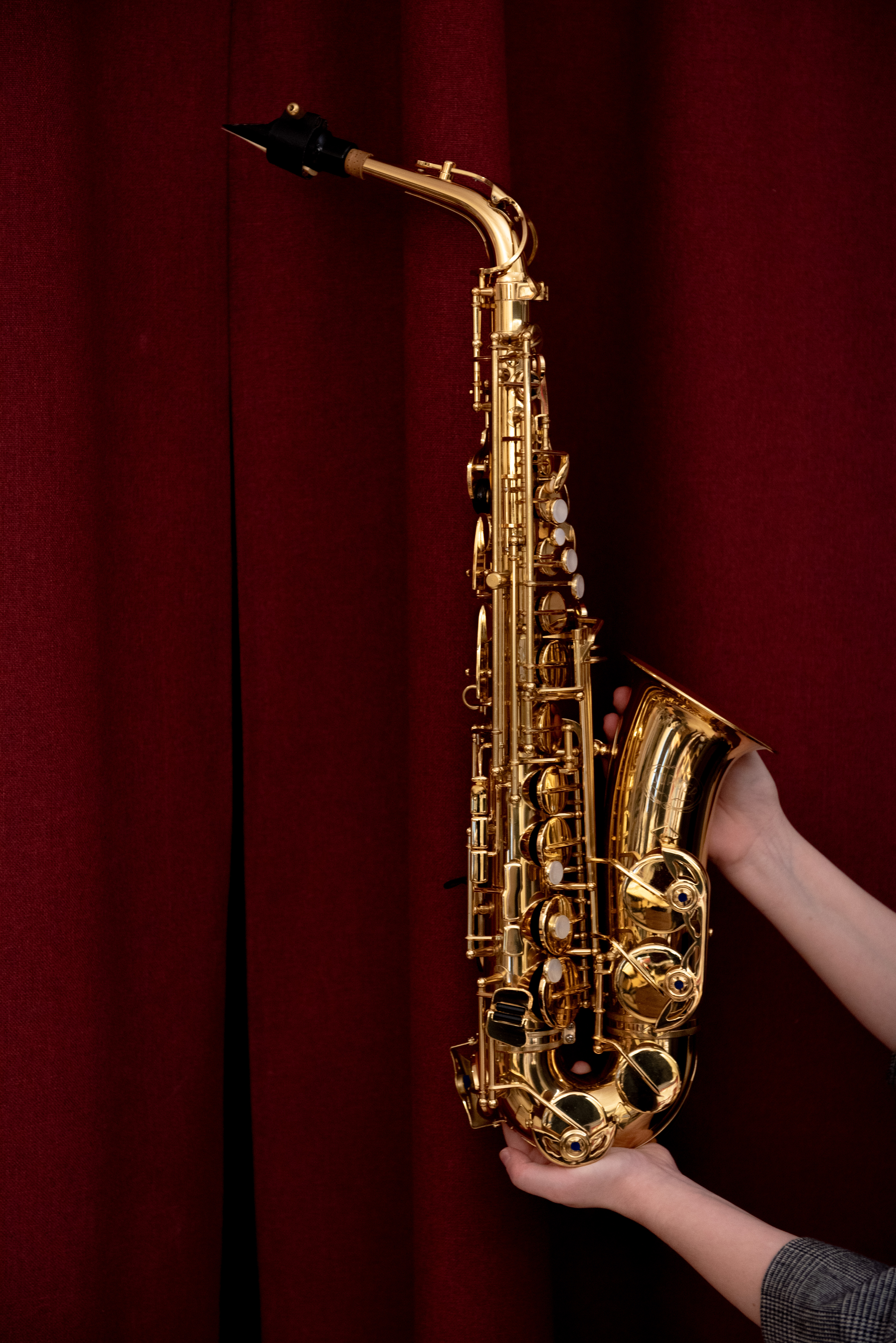 Bild på en saxofon mot ett vinrött skynke